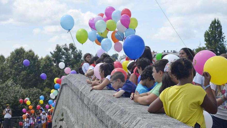 Niños del campamento urbano durante la tirada de globos de ayer, en el puente Romano. // Iñaki Osorio