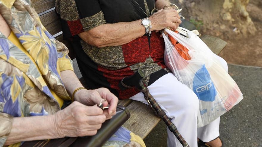 Dues persones grans en un banc de la ciutat.