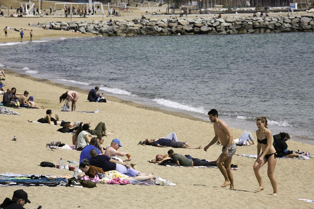 Persones a la platja de la Barceloneta.