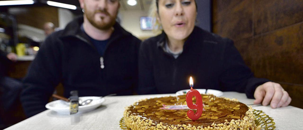 Lorena Uría sopla la tarta con el número &quot;9&quot; junto a su marido en una cafetería de Mieres.