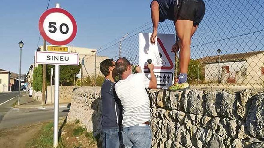 Varias personas colocan ayer uno de los carteles pidiendo respeto a los ciclistas en Sineu.