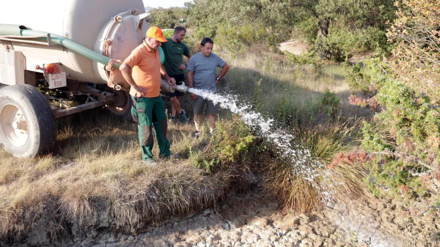 Els caçadors, en col·laboració amb un pagès, omplint una bassa assecada a la vall del Llémena