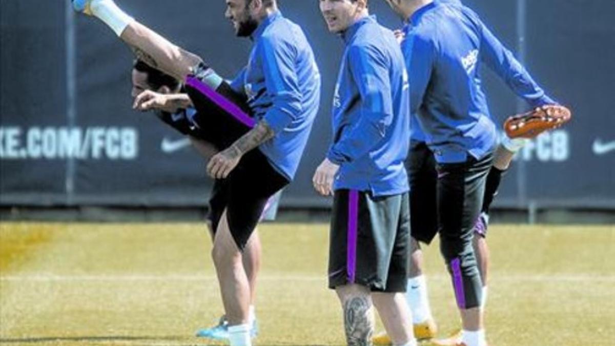 Alves, Messi e Iniesta se ejercitan en el entrenamiento de ayer del Barça.