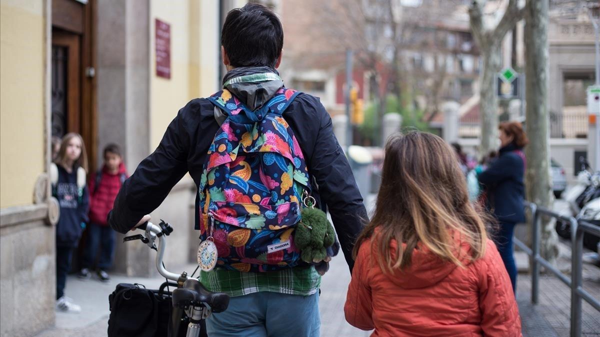 Un padre acompaña a su hija a la escuela
