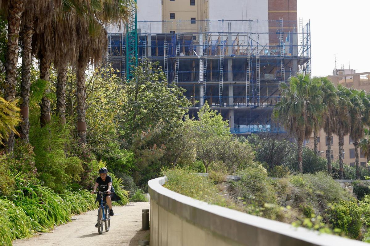 Una ciclista con la edificación de viviendas al fondo