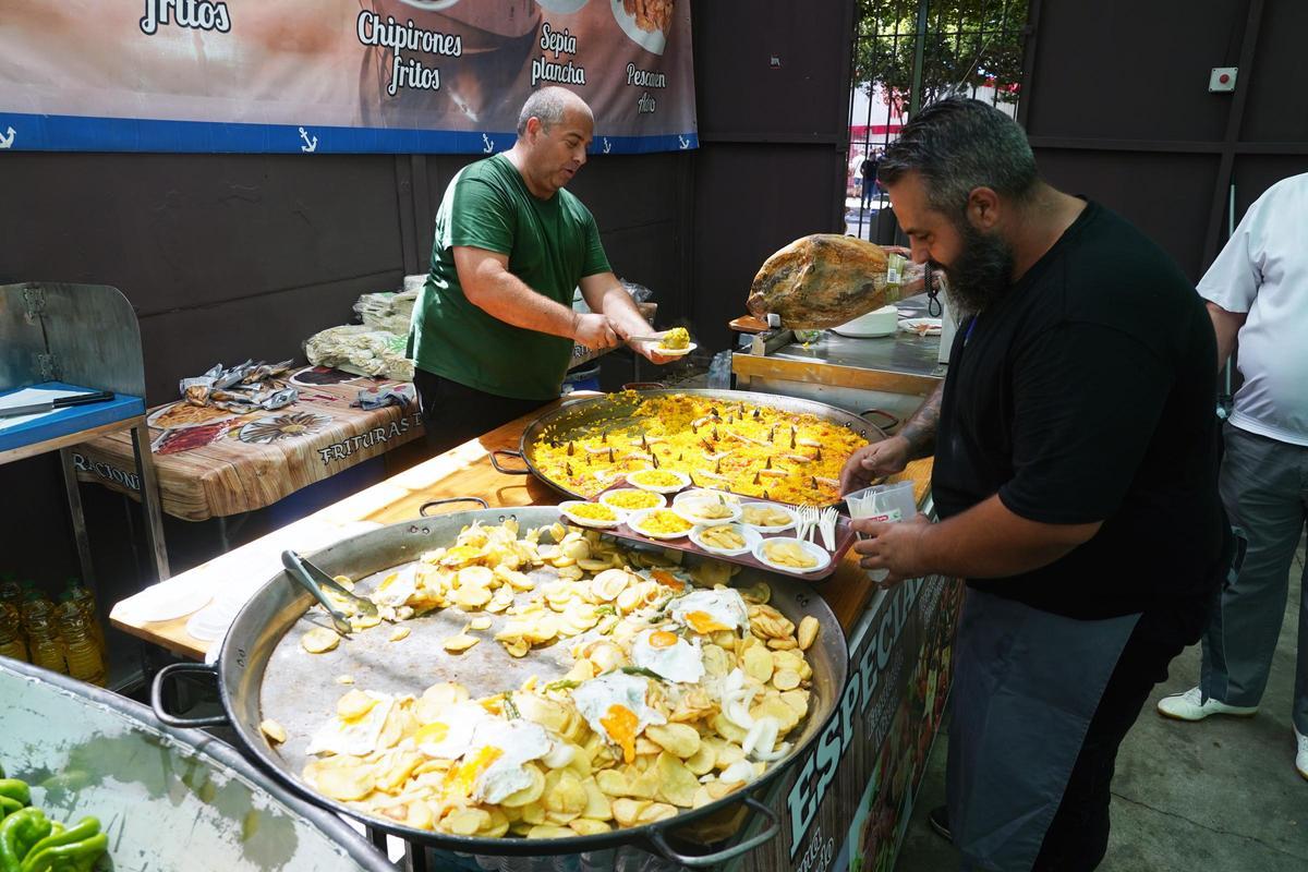 Dos cocineros preparan paella y patatas con huevo y pimientos en una Caseta del Real