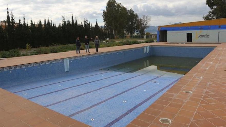 Los vecinos junto a la piscina principal en el abandonado complejo deportivo de Campanillas de la calle Fausto, esta semana.