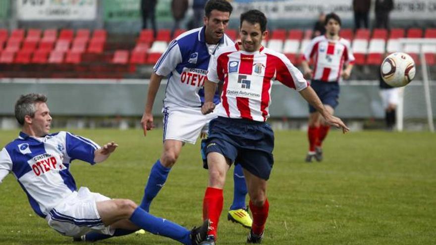 Ángel, del Tuilla, despeja un balón ante el jugador del Candás Saúl. Por detrás, el arlequinado Leiras.