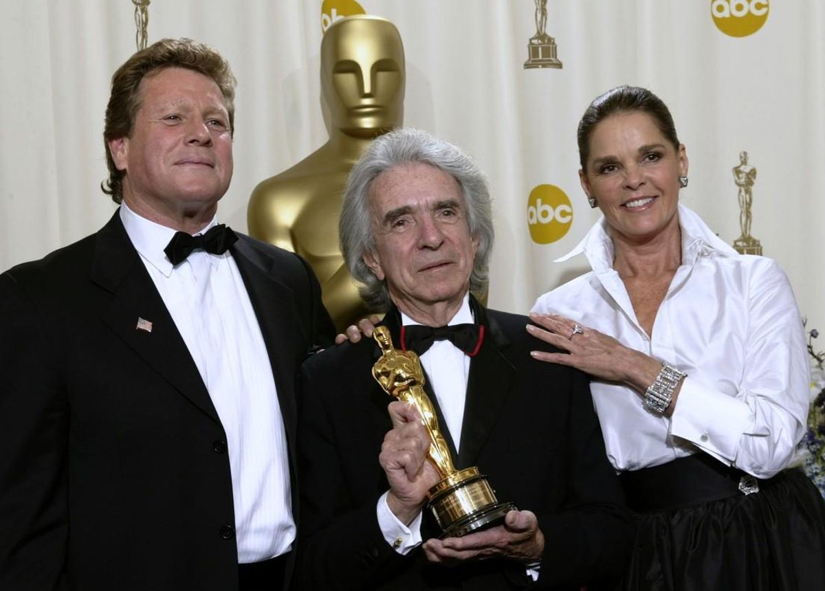 Arthur Hiller (C) holds his Jean Hersholt Humanitarian Award while standing with Ryan O’Neal (L) and Ali McGraw (R) during the 74th annual Academy Awards in Hollywood, California, U.S. March 24, 2002. REUTERS/Mike Blake/File Photo