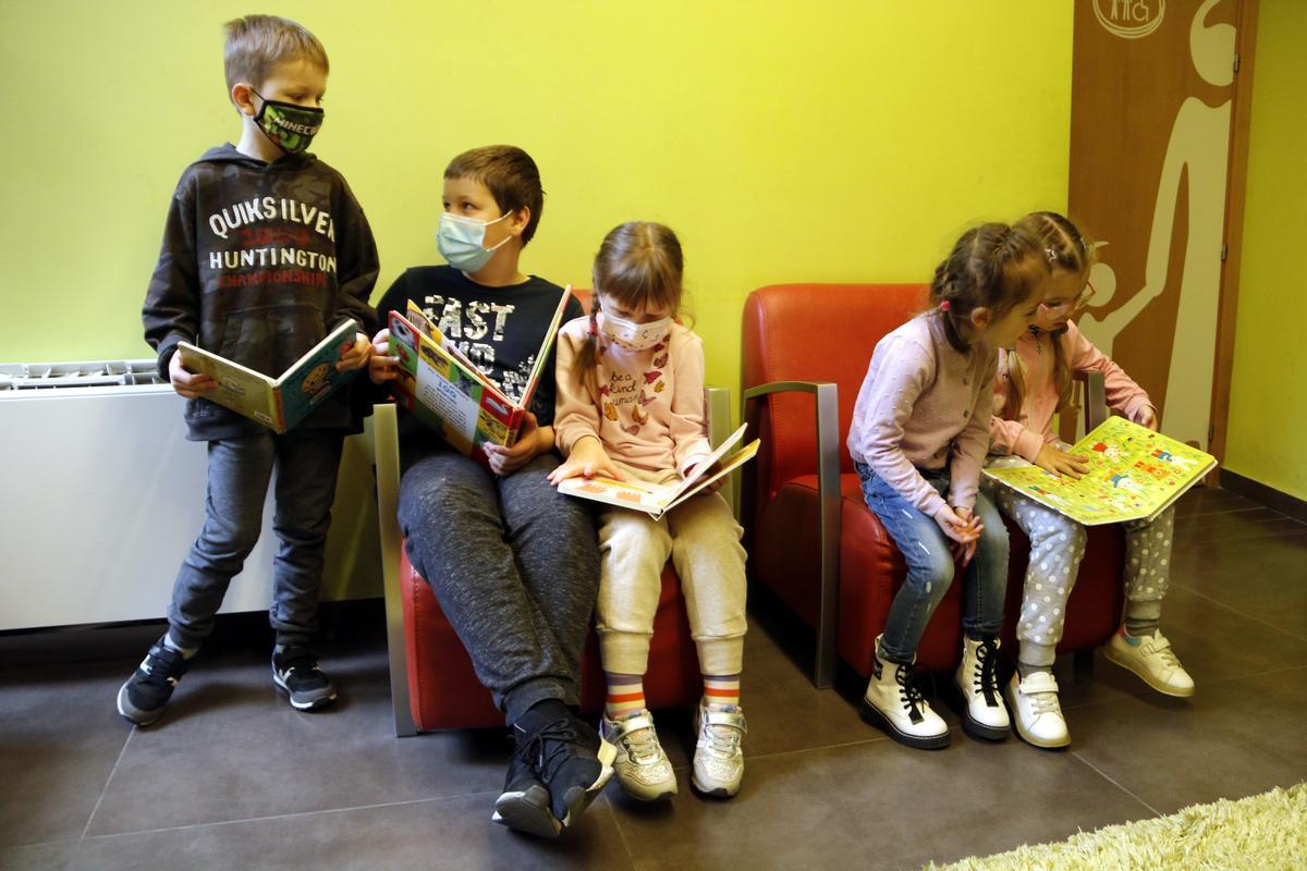 Varios niños recién llegados de Ucrania miran cuentos en la biblioteca de Guissona.