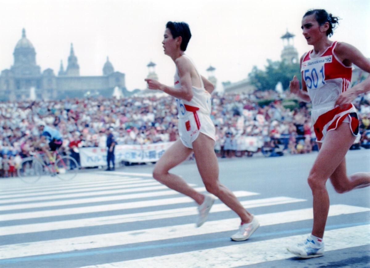 Valentina Yegorova (derecha), del Equipo Unificado, corre junto a Yuko Arimori, de Japón, en dirección a la montaña de Montjuïc y al Estadio Olímpico en la prueba femenina de Maratón, en Barcelona, el 1 de agosto de 1992. Al fondo, el Palau Nacional.