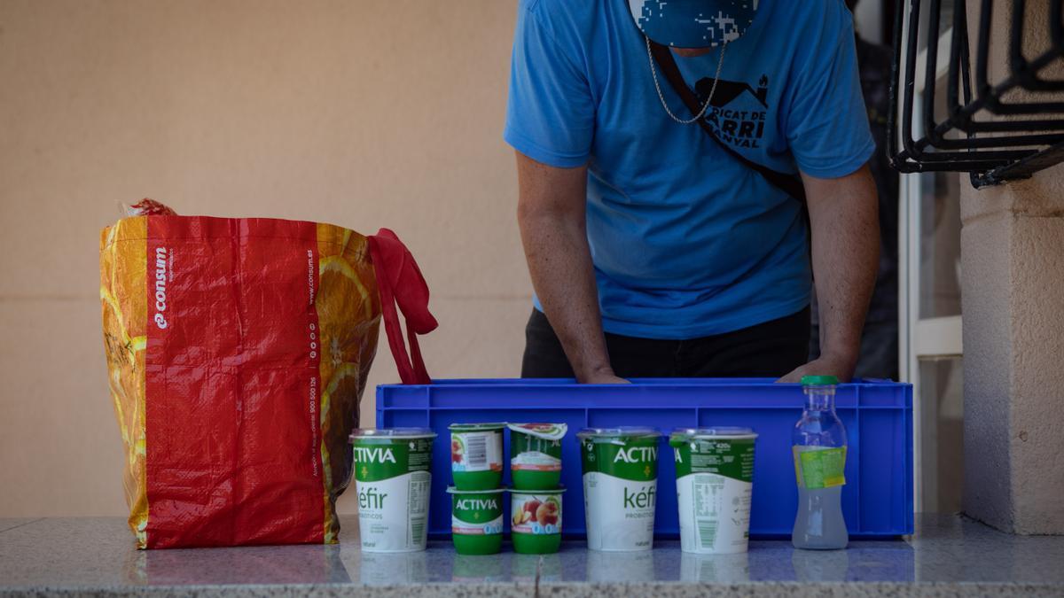 Una persona recoge los productos de la canasta que le ha proporcionado el Banco de Alimentos.
