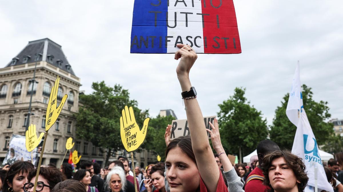 París, 03/07/2024.- Un manifestante sostiene una pancarta &quot;Todos somos antifascistas&quot; durante una manifestación contra la extrema derecha