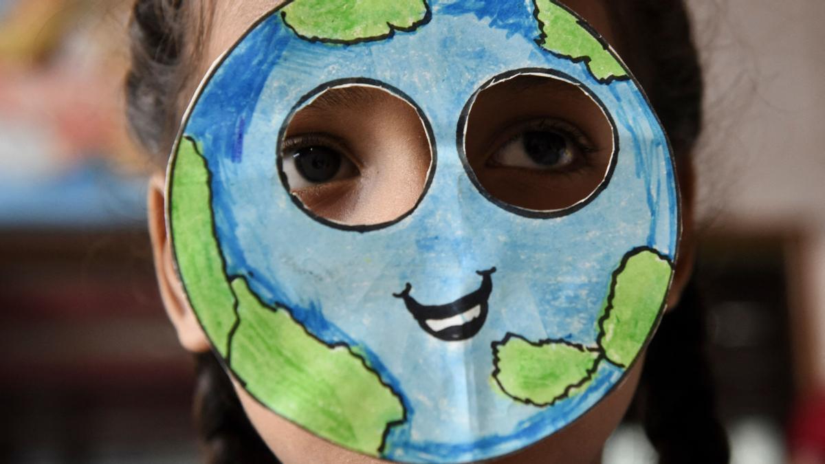 Un estudiante con una máscara hecha con la forma del planeta tierra durante un evento con motivo del Día de la Tierra en una escuela en Amritsar el 22 de abril de 2022.