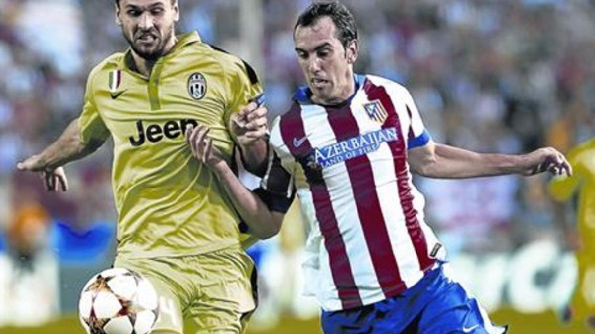Llorente y Godín pugnan por un balón en el encuentro de ayer disputado en el Vicente Calderón.