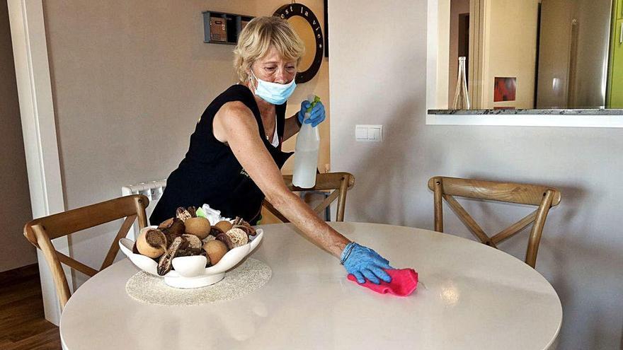 Una treballadora neteja la taula del menjador d&#039;un apartament de Sant Antoni de Calonge.