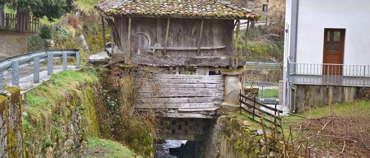 Hórreo a la entrada del pueblo bajo el que discurre el río Caleao.