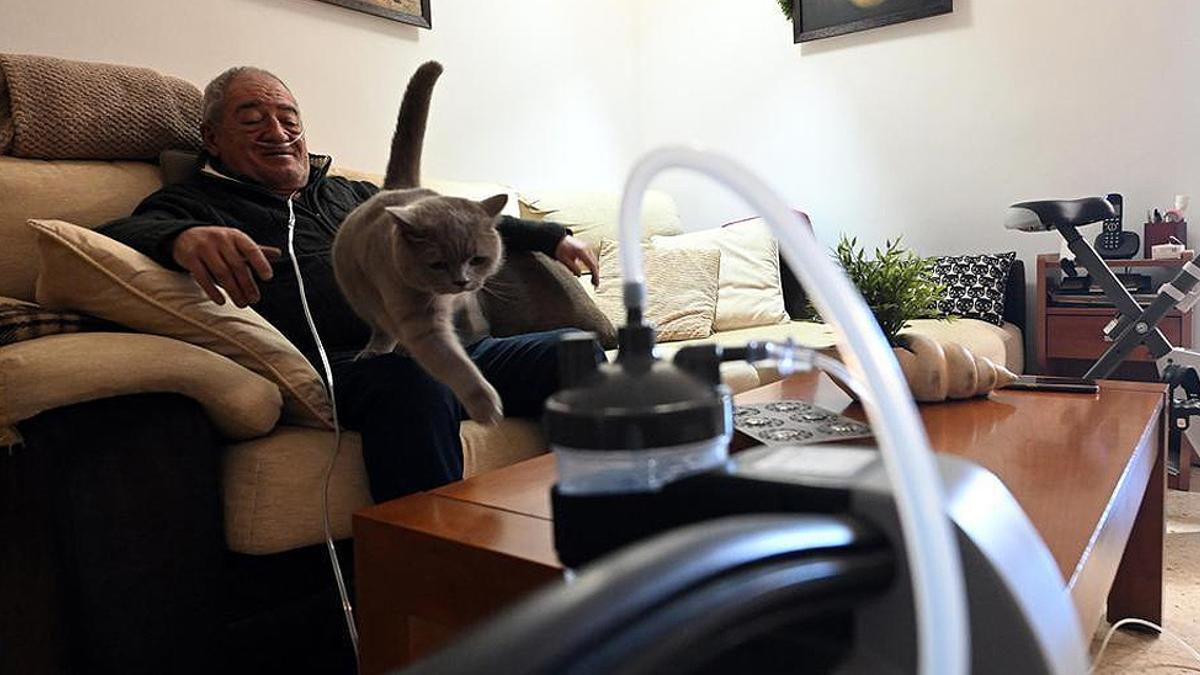 Salvador Mañosas, enfermo de EPOC, en su casa de Barcelona con su gato Tom.