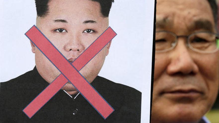 Activista sostiene una pancarta en contra de Kim Jong-un.