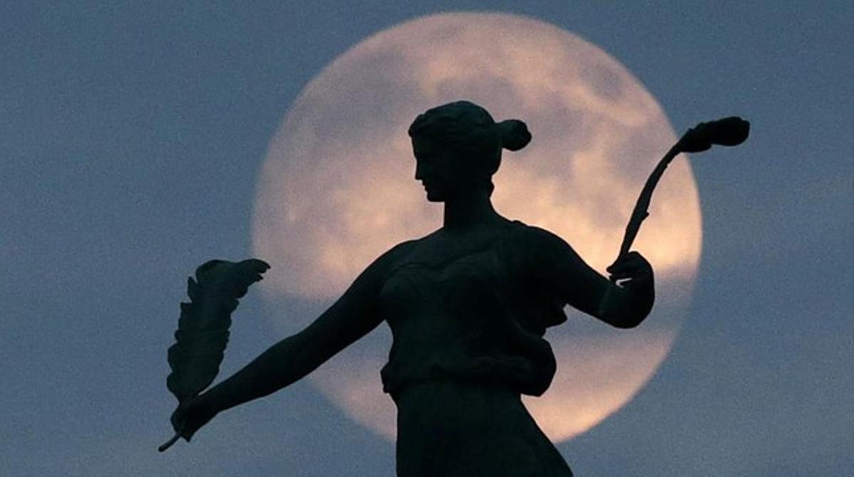 La luna tras la estatua de la Victoria en Des Moines, Iowa.