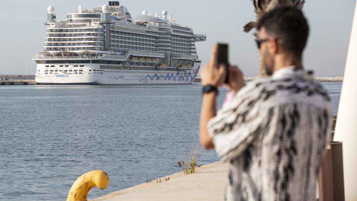 Una persona fotografía a un crucero en el puerto de Alicante