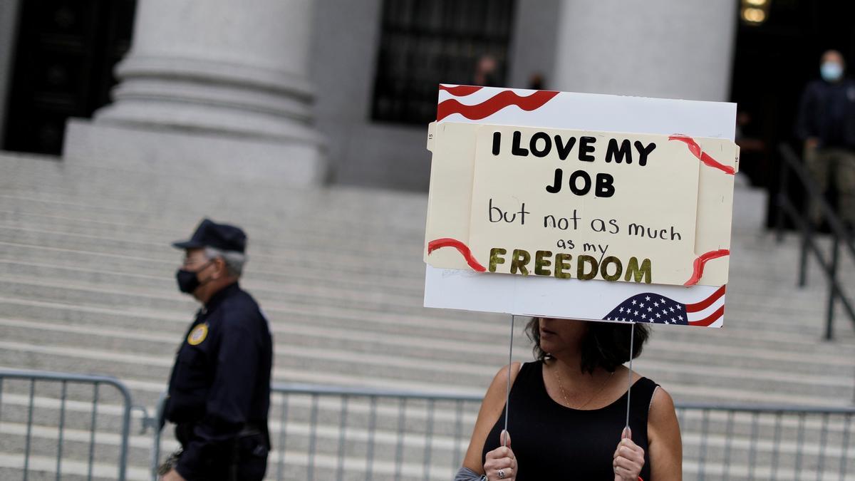 Una mujer, con una pancarta en la que se puede leer &quot;Amo mi trabajo, pero no tanto como [amo] mi libertad&quot;, en Nueva York, el pasado 12 de octubre.