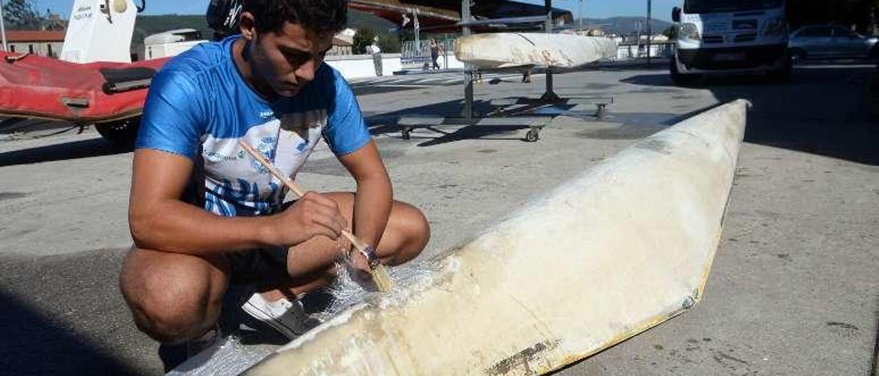 Un palista aplicando poliéster para reparar una canoa. // Noé Parga