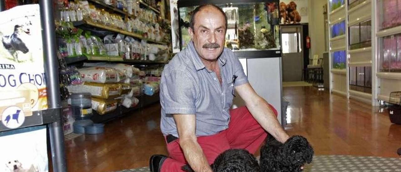 Anselmo posa con dos cachorros en la tienda de mascotas El Arca en Vigo.