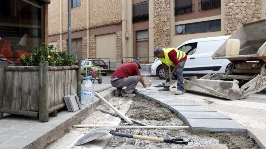 Operaris treballen per rebaixar la vorera davant d&#039;un pas zebra