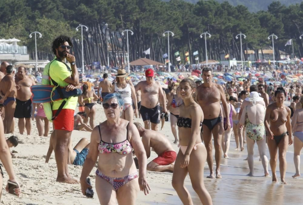 El buen tiempo anima a los bañistas en la playa de Samil