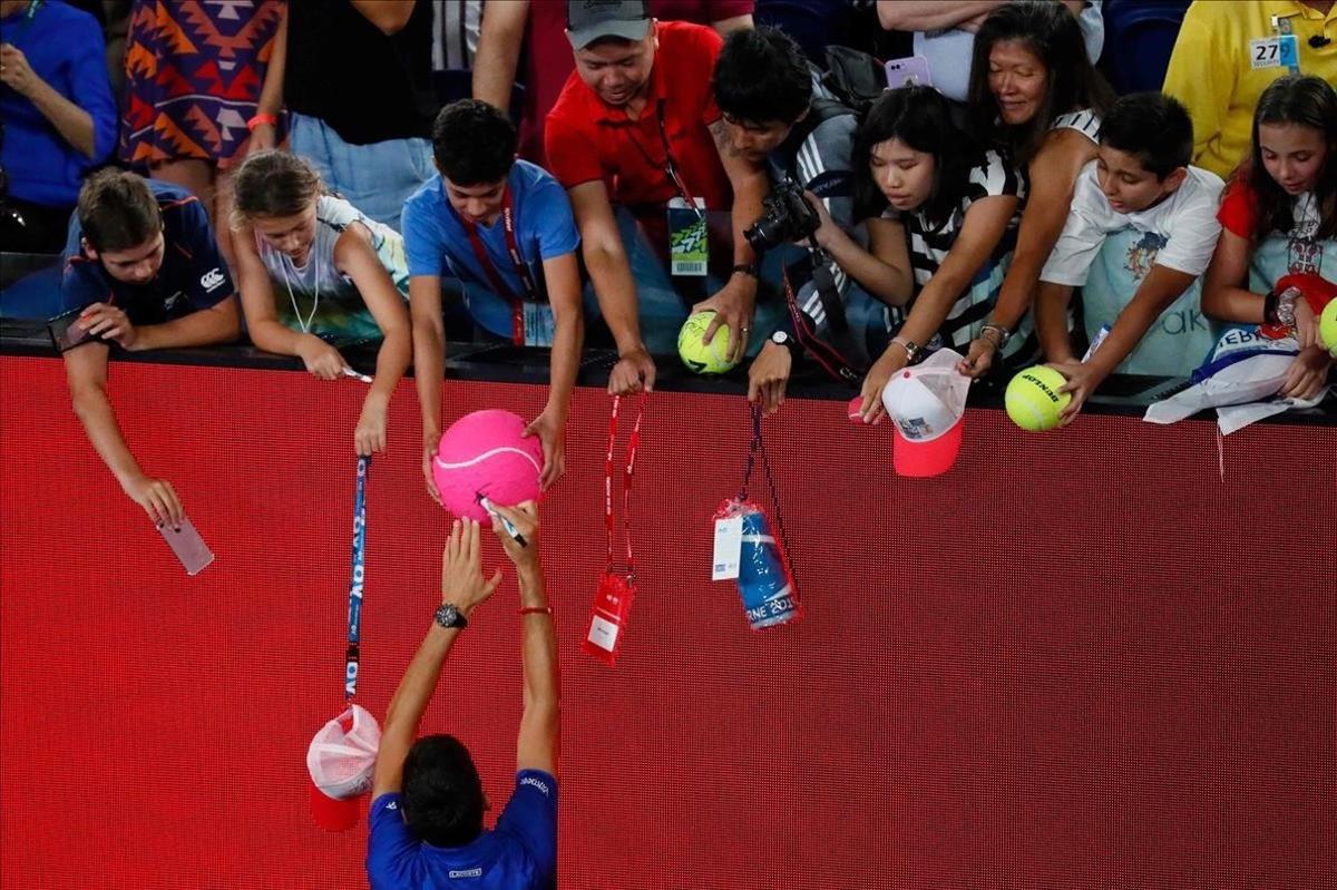 Novak Djokovic, de Serbia, firma autógrafos después de vencer a Lucas Pouille, de Francia, en su semifinal de semifinales del torneo de tenis Open de Australia en Melbourne.