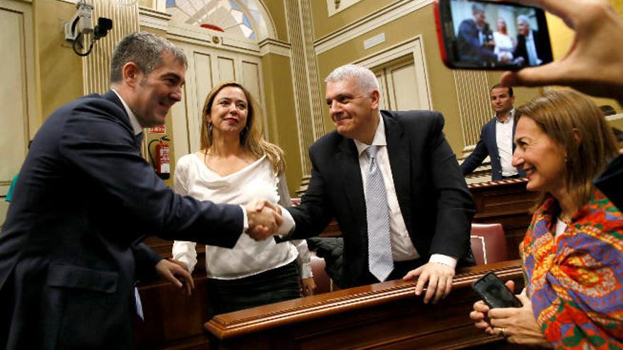 El presidente Fernando Clavijo saluda al socialista Manuel Marcos Pérez delante de Dolores Corujo en el Parlamento.