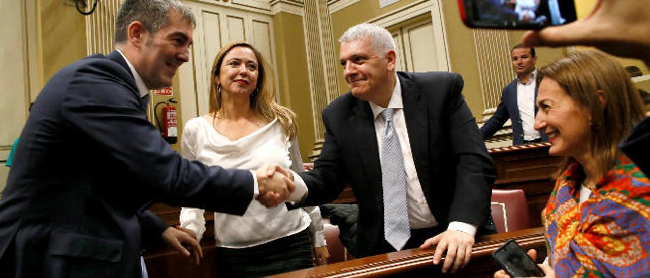 El presidente Fernando Clavijo saluda al socialista Manuel Marcos Pérez delante de Dolores Corujo en el Parlamento.