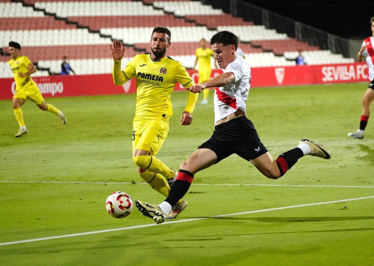 Joseda Menargues intenta frenar a un futbolista del conjunto sevillista.