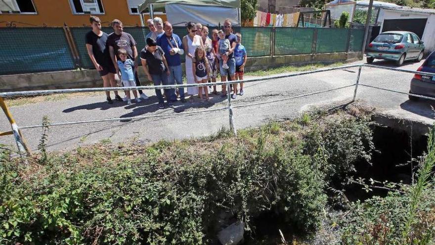 Un grupo de vecinos del Camiño do Estrobo, en el puente que se inclina sobre el río Fondón. // M.G. Brea