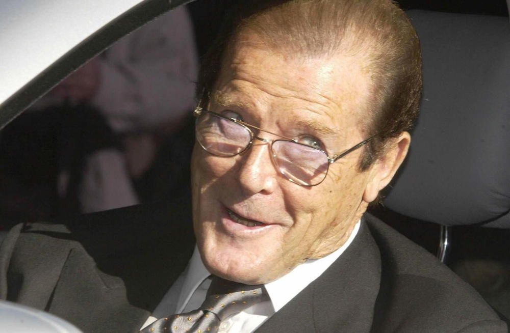 ROGER MOORE ARRIVES AT BUCKINGHAM PALACE