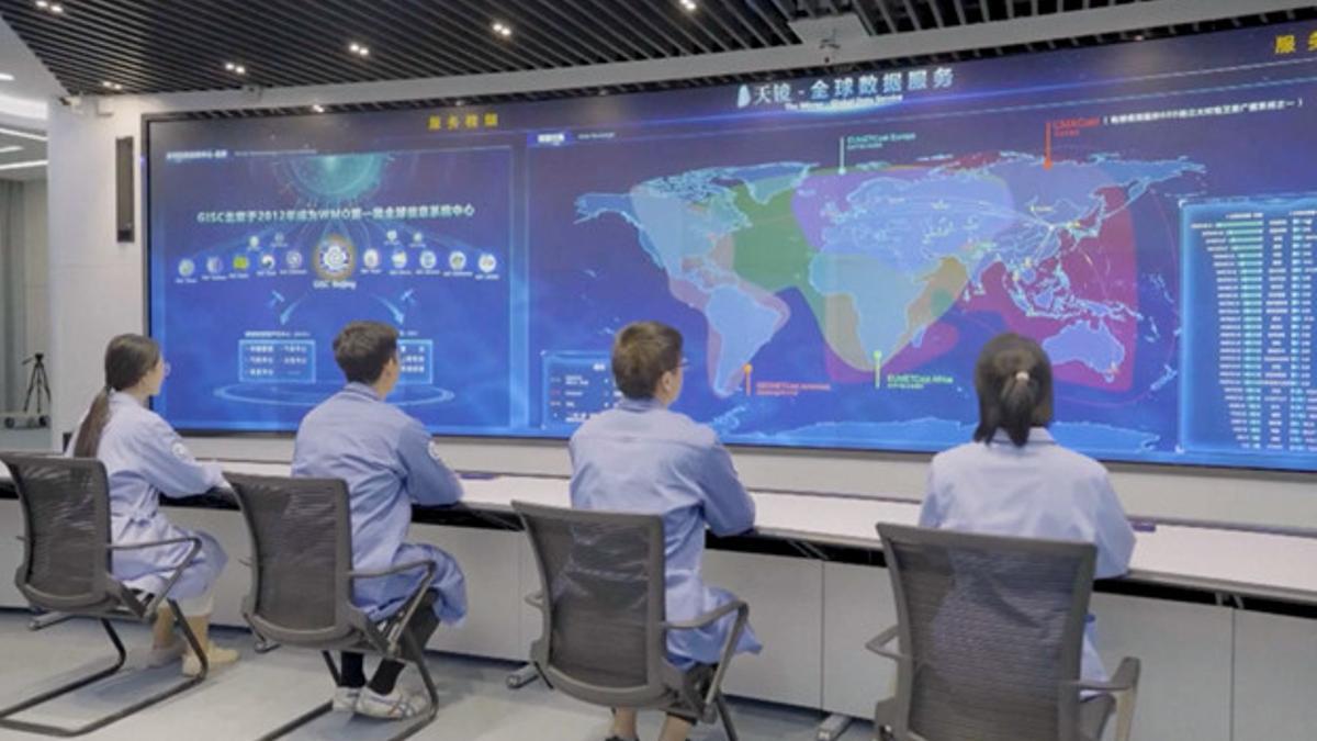 Miembros del personal leyendo datos meteorológicos en la pantalla, en Pekín.