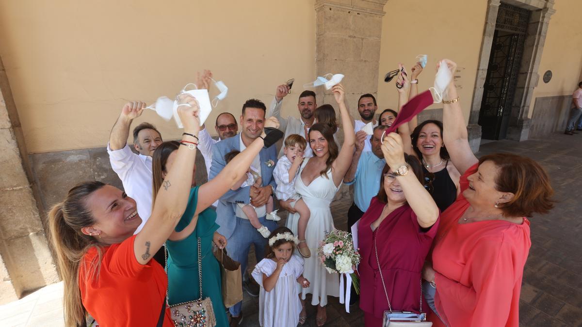 Invitados y contrayentes agitan sus mascarillas tras una boda en el Ayuntamiento de Castelló.