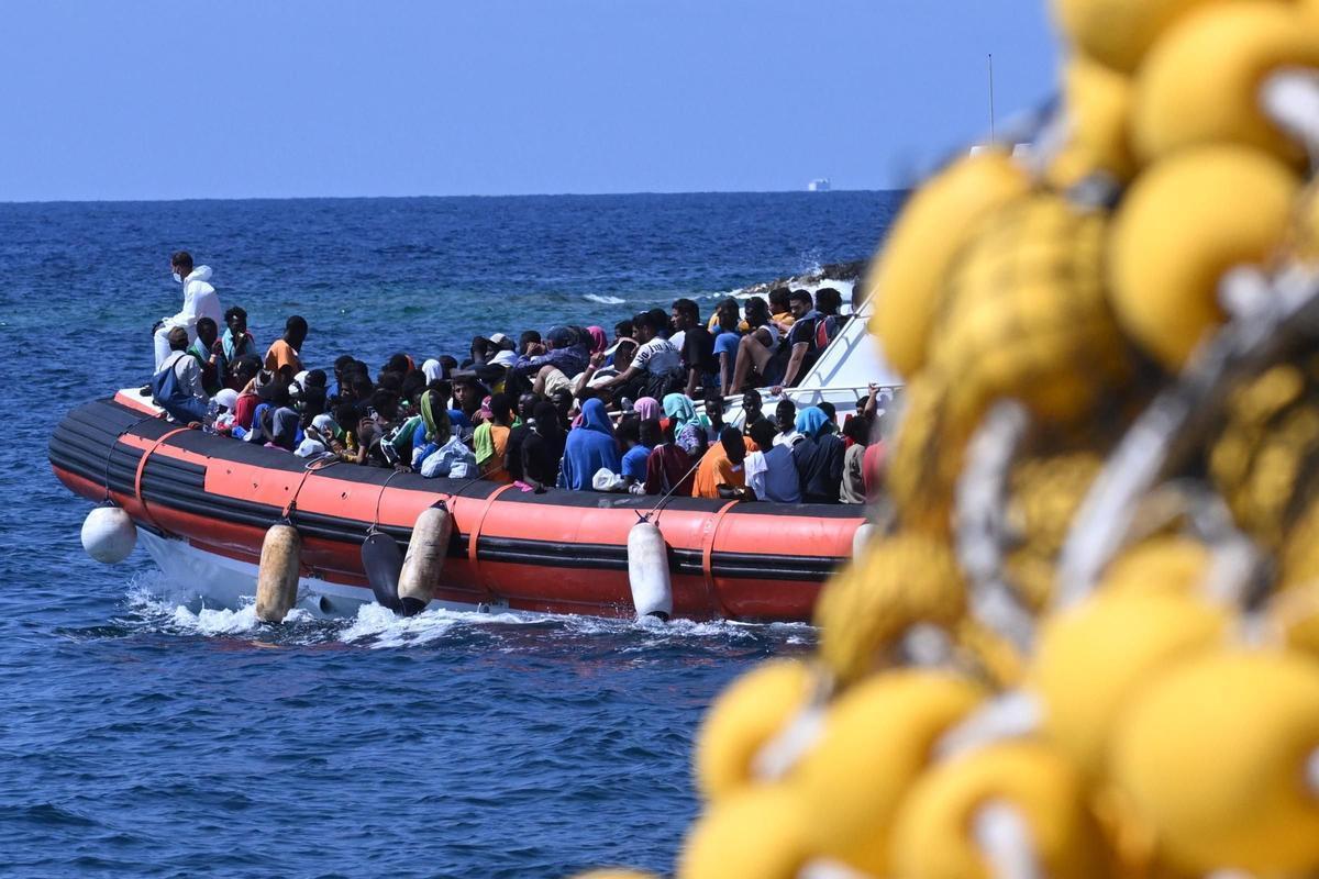Un grupo de inmigrantes a bordo de un barco frente a las costas de la isla italiana de Lampedusa.