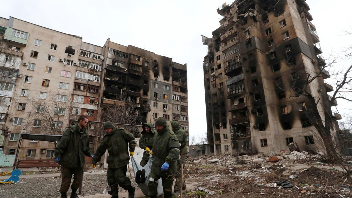 Service members of pro-Russian troops collect bodies of the dead to take them to the morgue in Mariupol