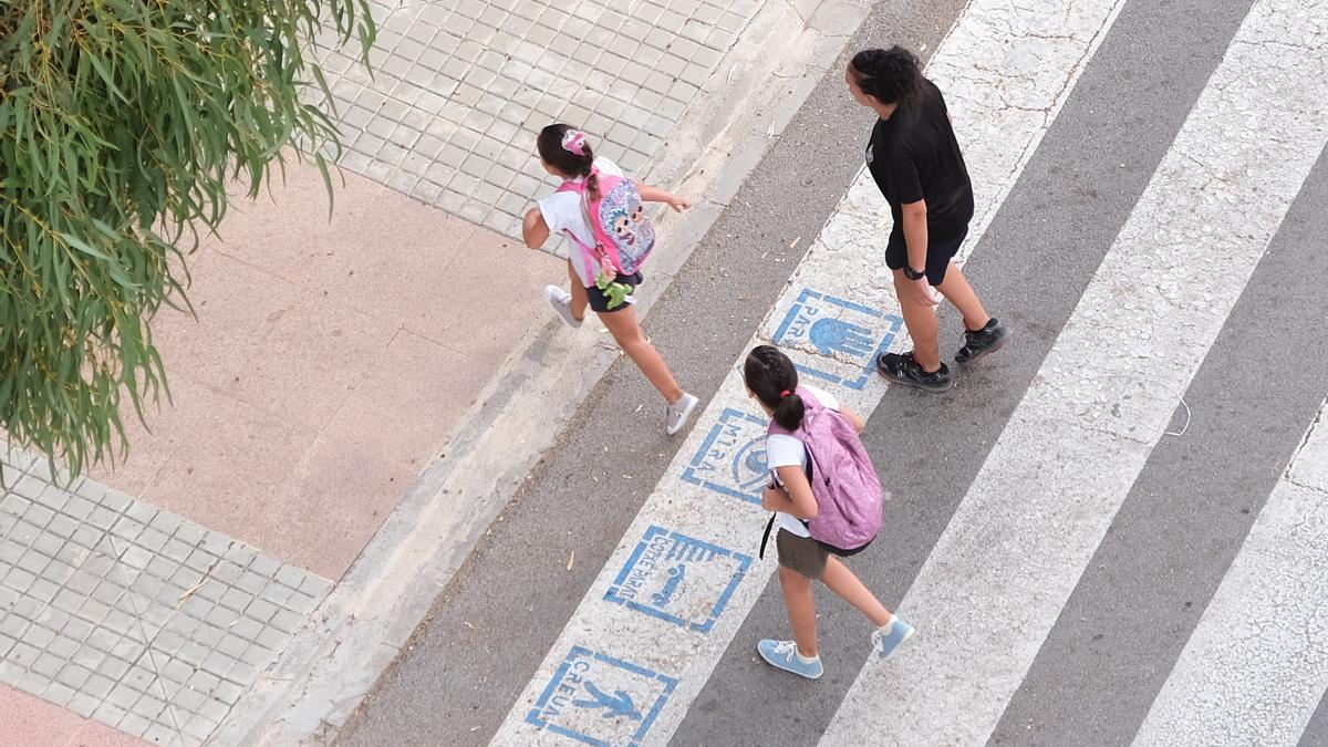 Una mujer acompaña a dos niñas en el inicio del curso escolar.