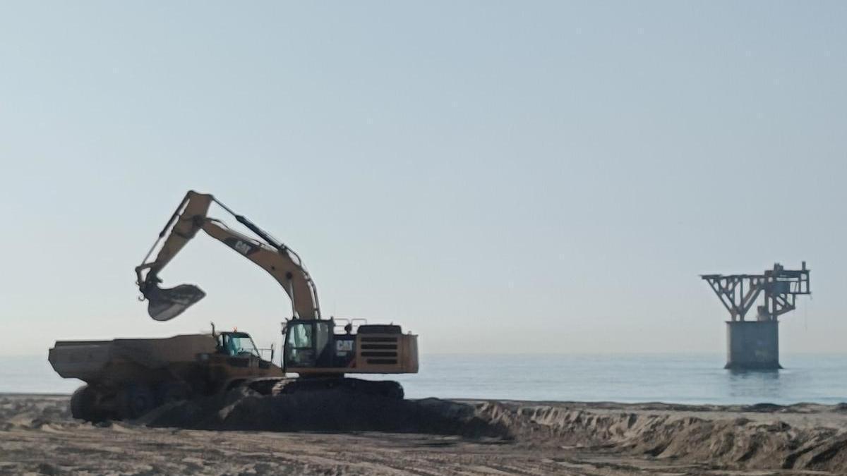 Maquinaría pesada repone arena en la playa de El Cable en unas actuaciones de este verano.