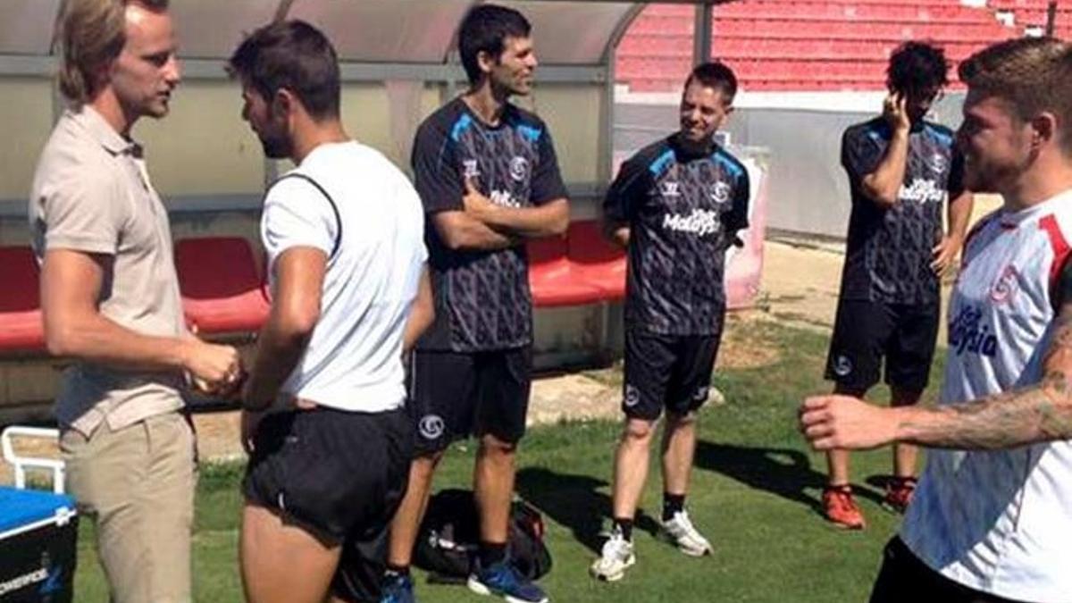 Rakitic hablando con sus excompañeros antes del entrenamiento.