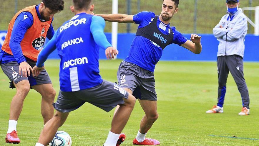 Fernando Vázquez, al fondo, observa a Sabin Merino y Borja Valle en el entrenamiento de ayer.