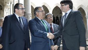 El presidente de la Generalitat, Carles Puigdemont, saluda al ministro del Interior, Juan Ignacio Zoido, ante el ’conseller’ de Interior, Jordi Jané, el 10 de julio, antes del comienzo de la reunión de la Junta de Seguridad.