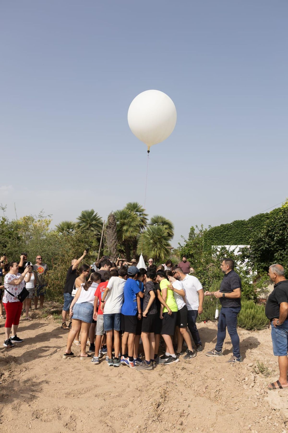 Alumnos lanzan el globo desde una finca del Camp d'Elx