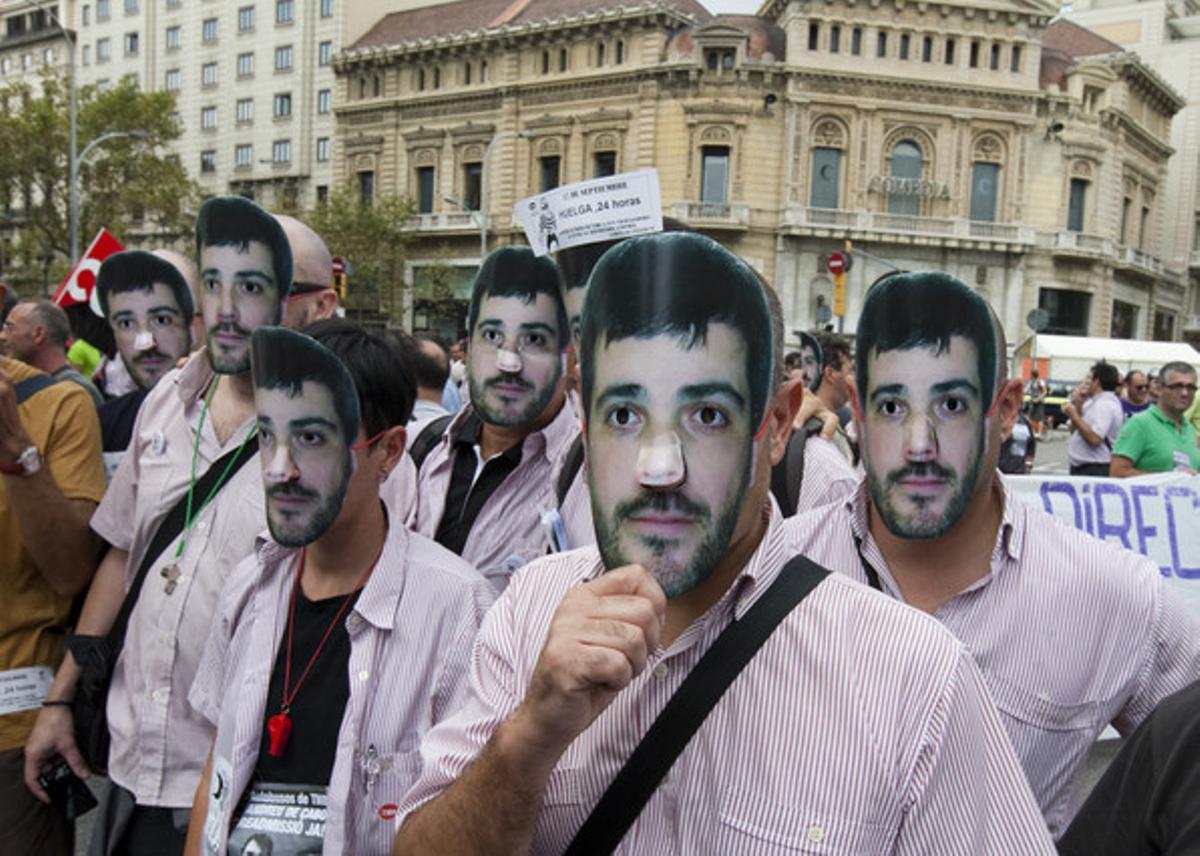 Trabajadores de Bus y Metro de Barcelona, en una manifestación con la máscara de un compañero despedido por denunciar irregularidades.