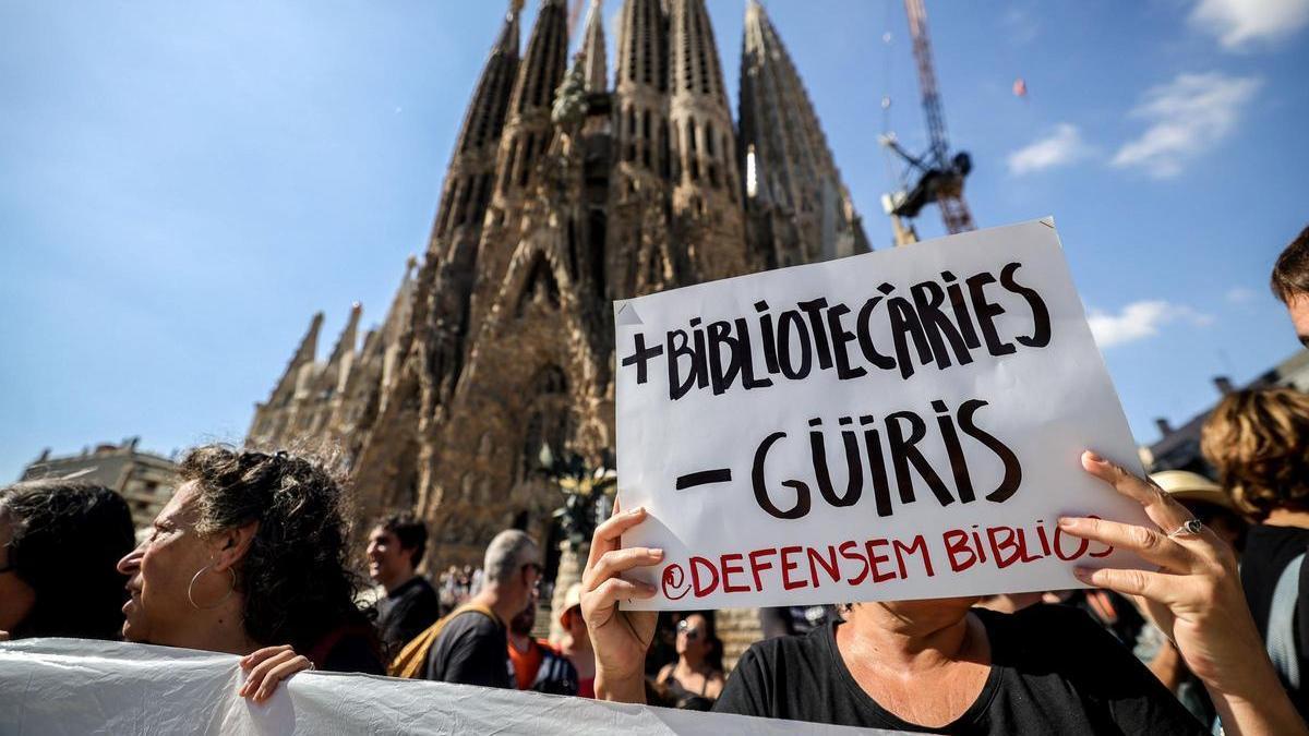 Trabajadores de las bibliotecas de Barcelona protestan frente a la Sagrada Familia para reclamar mejoras en sus condiciones laborales.