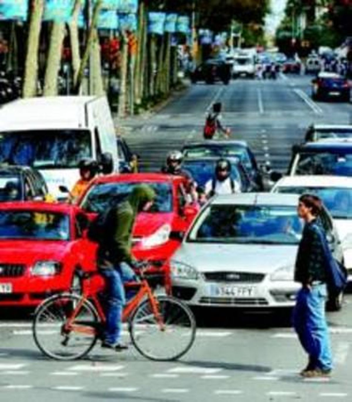 Un vianant i un ciclista travessen la Diagonal davant els cotxes. Un vianant i un ciclista travessen la Diagonal davant els cotxes.