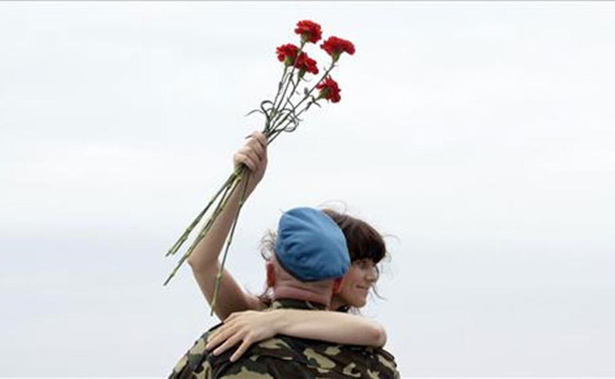 Una dona abraça un paracaigudista rus al port oriental de Vladivostok (Rússia).